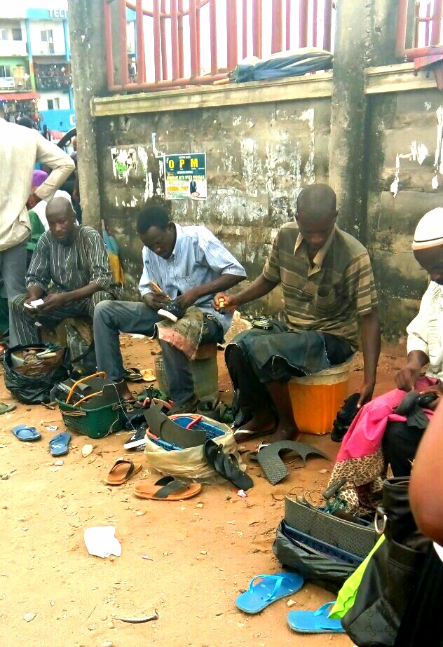 A cobbler repairing a damaged shoe by hand